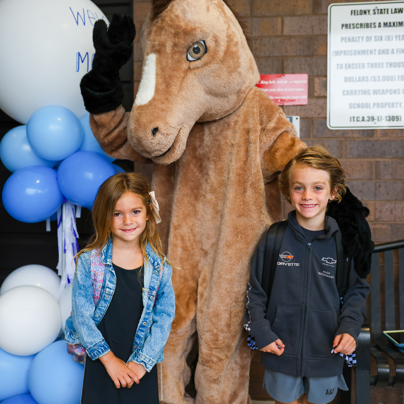 two students with mustang mascot